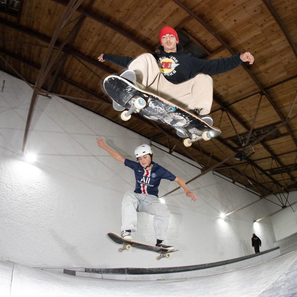 Deux jeunes hommes sur un skateboard réalisant une figure